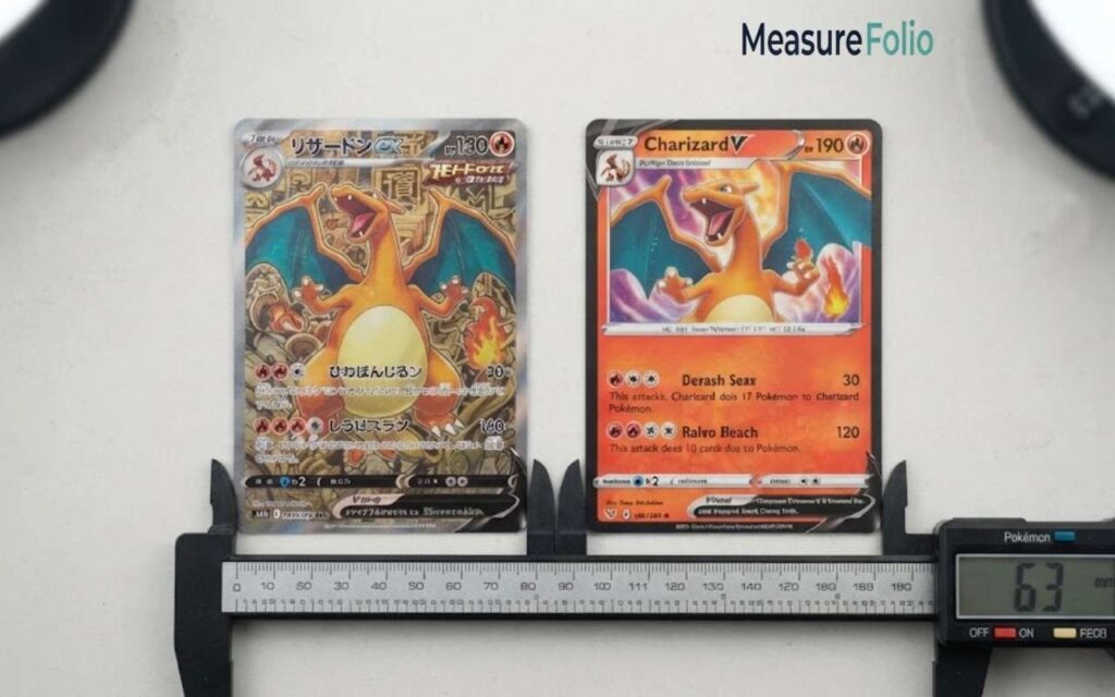 Two Charizard cards—one with Japanese text and one with English text—placed side by side on a clean white surface with a digital caliper measuring their width.